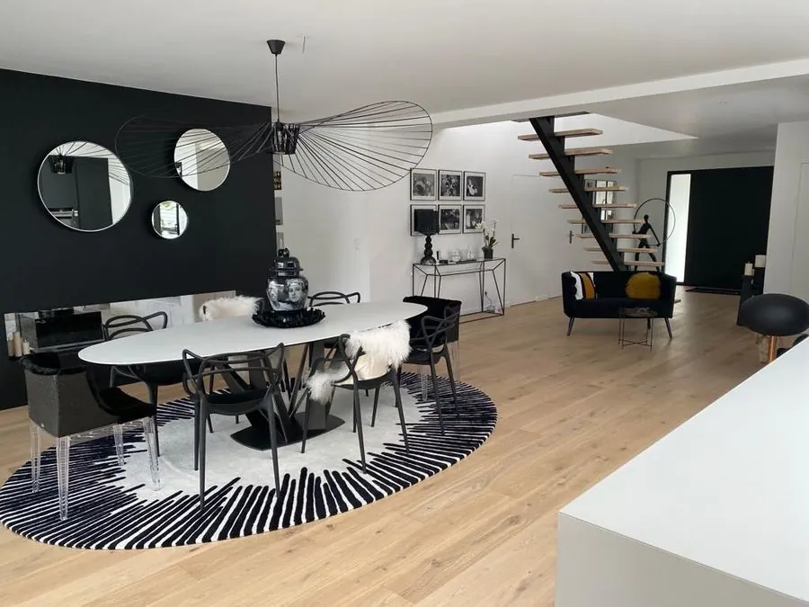 Séjour aménagé avec escalier bois dans une maison livrée par MOE LEMAN